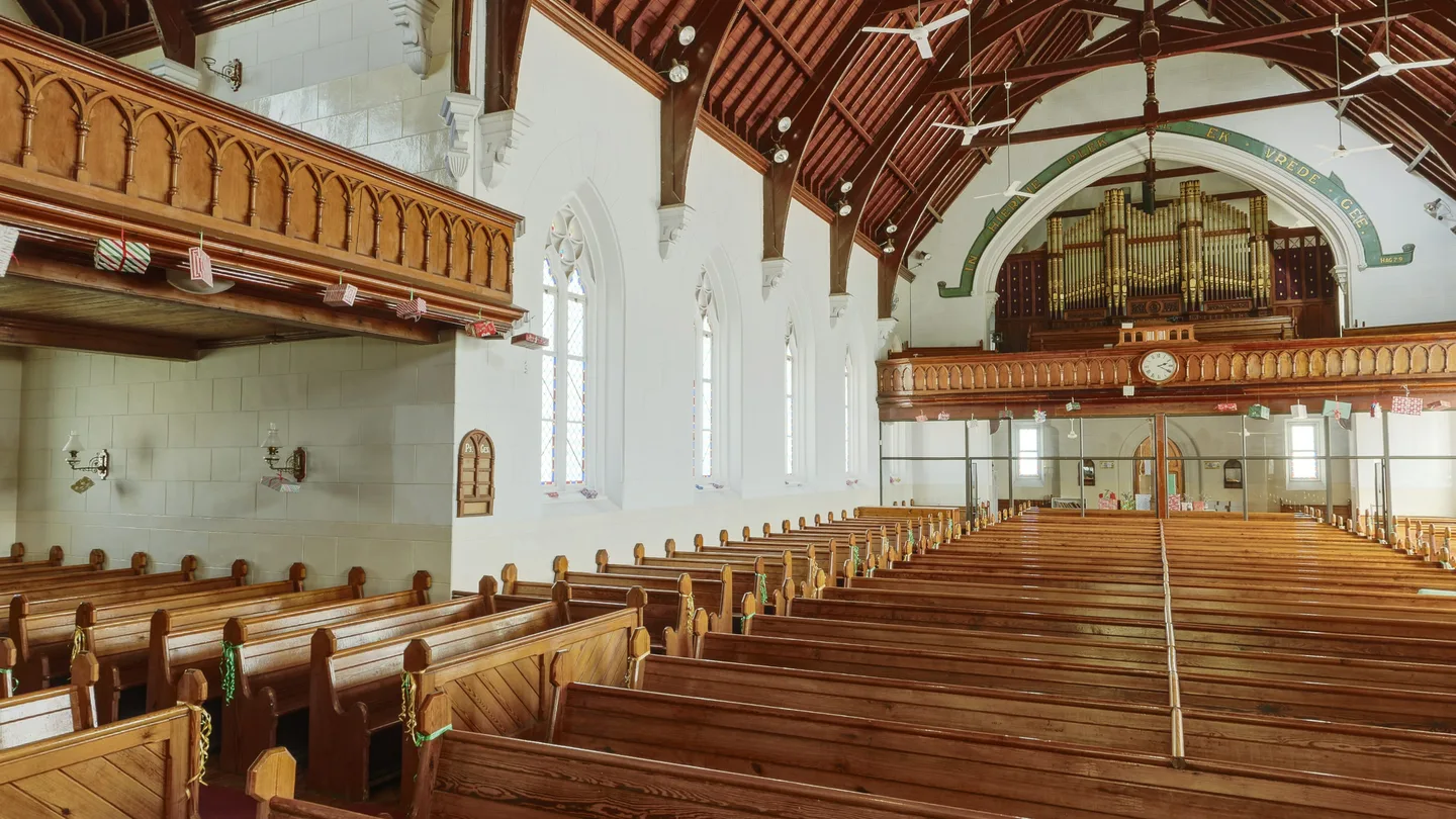 De kerkzaal met houten banken, het orgel en de klok boven de galerij.