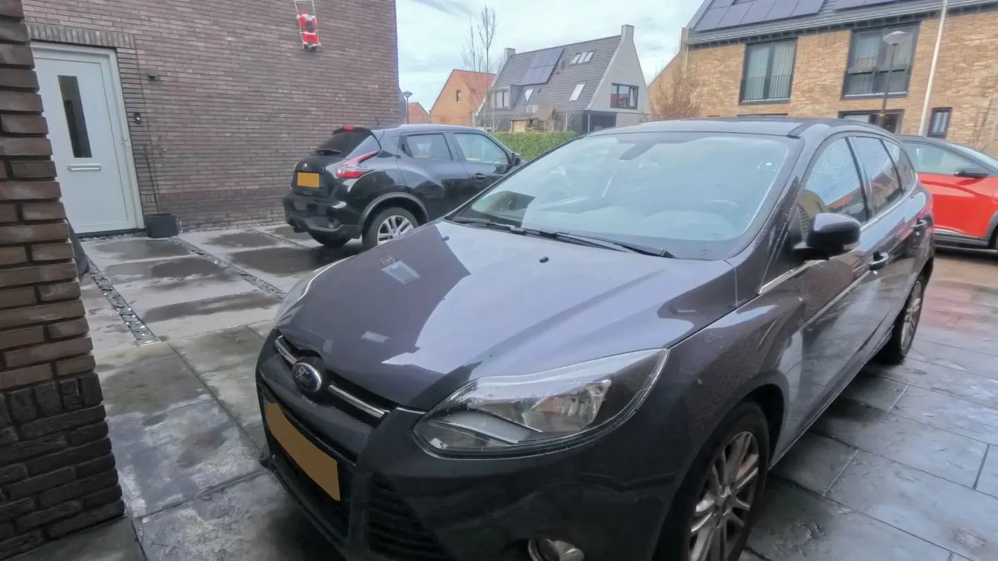 The front of a dark grey car on a driveway, from the demo at a fictitious dealership.